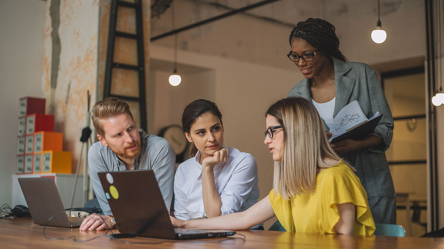 Image of a group of employees working from a laptop together