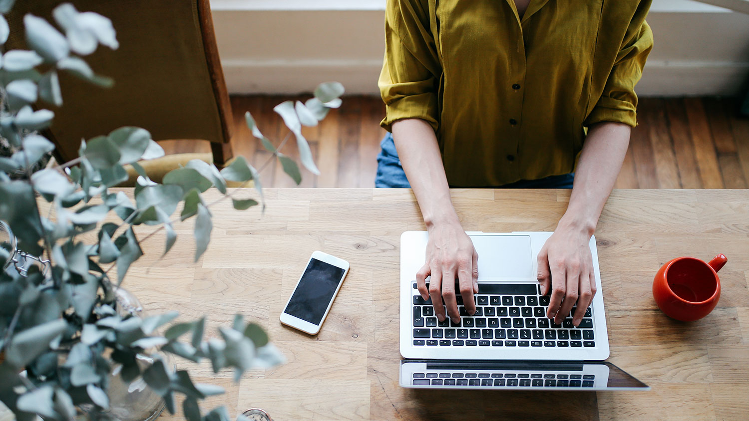 Image of a woman's hands typing on a laptop