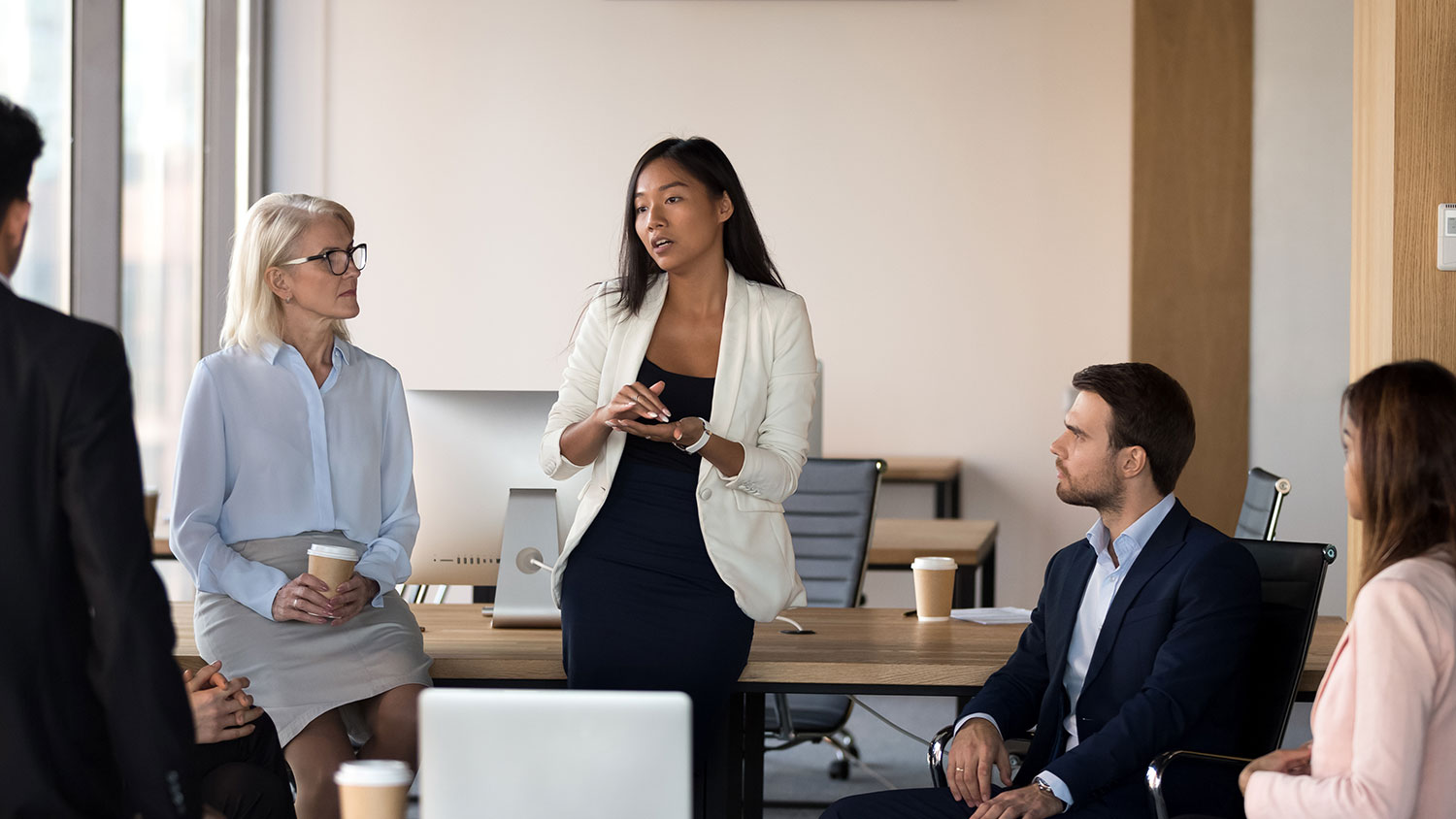 Image of a woman presenting in front of colleagues