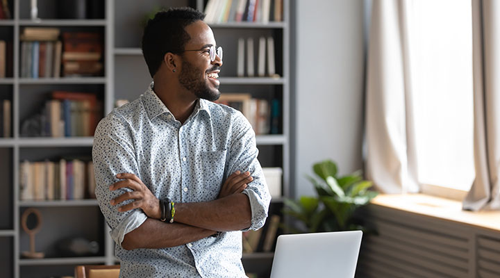 male office worker smiling looking out the window